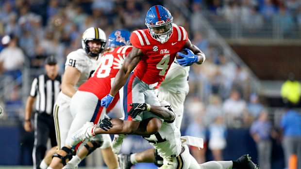 Oct 28, 2023; Oxford, Mississippi, USA; Mississippi Rebels running back Quinshon Judkins (4) leaps over Vanderbilt Commodores defensive back Savion Riley (21) as he makes the tackle during the first half at Vaught-Hemingway Stadium. Mandatory Credit: Petre Thomas-USA TODAY Sports